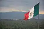 Mexican flag with countryside in background
